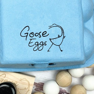 May include: A blue cardboard egg carton with the words 