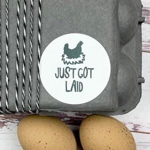 May include: A gray egg carton with a white sticker that says 