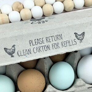 May include: A brown cardboard egg carton with a white label that reads 