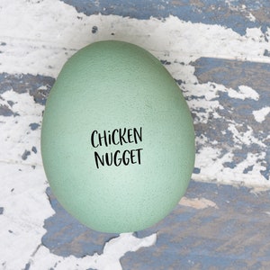 May include: A light green egg with the words 