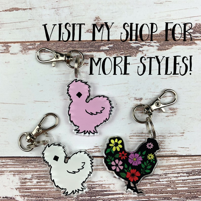 May include: Three different chicken keychain charms. One is pink and fluffy, one is white and fluffy, and one is black with a floral pattern.