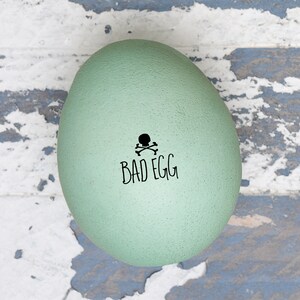 May include: A light green egg with a black skull and crossbones and the text 