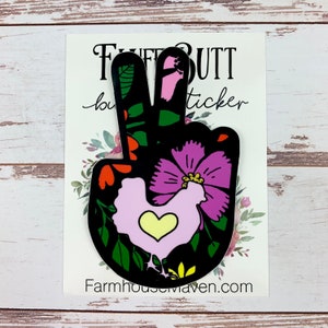 May include: Peace sign sticker with a floral design in shades of pink, green, red, and yellow. A pink chicken with a yellow heart is in the centre of the design. The sticker says "Fluff Butt Sticker" at the top and "Farmhousemaven.com" at the bottom.