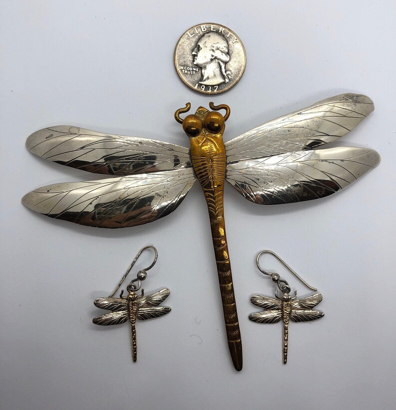 Puede incluir: Un conjunto de tres joyas de lib&eacute;lula de plata. Un broche de lib&eacute;lula grande de plata con cuerpo dorado y dos pendientes de lib&eacute;lula m&aacute;s peque&ntilde;os de plata con cuerpos dorados.