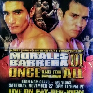 May include: A boxing poster advertising a fight between Morales and Barrera. The poster is red, yellow, and black with the text "Morales Barrera III Once and For All" in large, bold letters. The poster also includes the date and time of the fight, "Saturday, November 27 9PM ET/6PM PT", and the location, "From MGM Grand - Las Vegas".