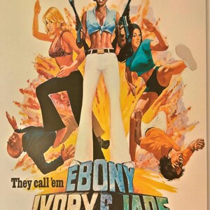 May include: Vintage movie poster for "3 Foxy Mama's Turned Loose..." featuring three women with guns, and the text "Ebony, Ivory & Jade." The poster has a retro, action-movie style with a colorful, dynamic composition.
