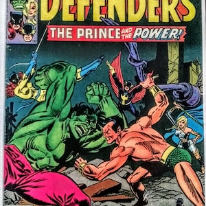May include: A comic book cover featuring The Defenders, a group of superheroes. The cover features the Hulk and the Sub-Mariner fighting, with other members of the team, including the Valkyrie, the  Doctor Strange, and the  Iron Fist, in the background. The cover text reads "The Defenders: The Prince and the Power!" and "It's the Hulk versus Sub-Mariner! And the dynamic Defenders are caught in the middle!"