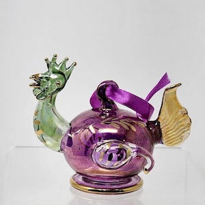 May include: A white ceramic mug with a black handle and the text "But First, Coffee" in a black, handwritten-style font. The mug is on a white surface.