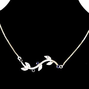 May include: A delicate silver necklace featuring a curved vine design with three clear leaf-shaped pendants and three small, dark blue gemstones. The necklace has a fine chain and is set against a black background.