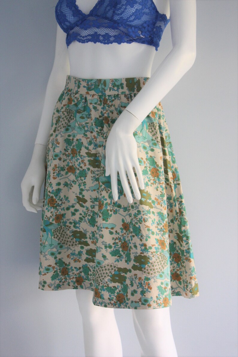 May include: A white, floral print skirt with a blue, green, and brown pattern. The skirt is knee-length and has a gathered waist.