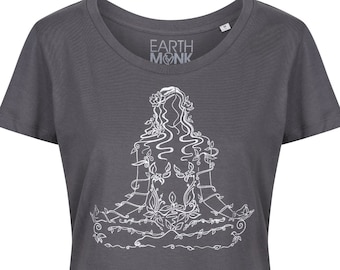 May include: A charcoal grey t-shirt with a white line drawing of a woman meditating with flowers and vines. The text "EARTH MONK" is printed on the shirt.