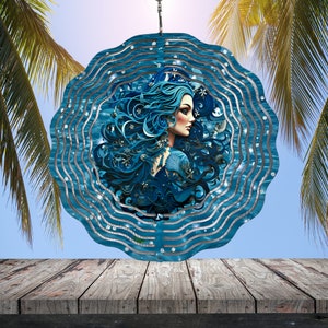 May include: A blue metal wind spinner with a swirling design featuring a woman with long blue hair and a blue background. The wind spinner is hanging from a chain.