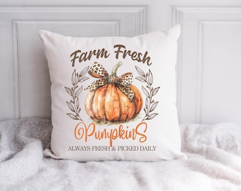 May include: White throw pillow with the text "Farm Fresh Pumpkins" and a watercolor illustration of a pumpkin with a leopard print bow. The text below the pumpkin reads "Always Fresh & Picked Daily."