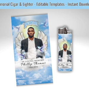 May include: A memorial cigar and lighter set featuring a portrait of a person with angel wings, doves, and a cloudy sky background. The text reads "In Loving Memory Phillip Thomas 1992-2023" and "Backwoods".