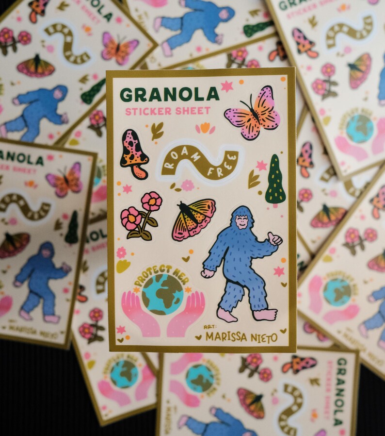 May include: A collection of "Granola Sticker Sheet" featuring whimsical illustrations. The stickers include a blue Bigfoot, butterflies, mushrooms, flowers, and the text "Roam Free" and "Protect Her". The artist's name, Marissa Nieto, is also included.