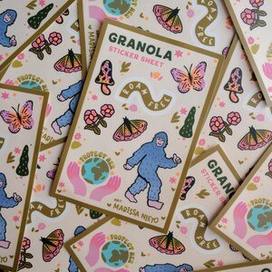 May include: A collection of "Granola" sticker sheets with a beige background and gold borders. Each sheet features a blue Bigfoot, butterflies, mushrooms, flowers, and the text "Roam Free" and "Protect Her".
