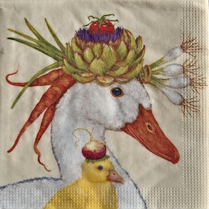 May include: A whimsical illustration on a napkin features a white goose adorned with a vegetable crown of artichoke, tomato, and purple thistle. Carrots and green onions complete the look. A yellow duckling wears a red onion hat.