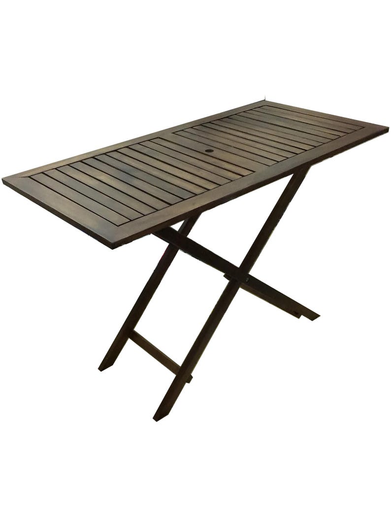 May include: A rectangular, dark brown wooden folding table. The tabletop features a slatted design with a small hole in the center. The legs form an X-shape, providing support. This outdoor table is perfect for a patio or deck.