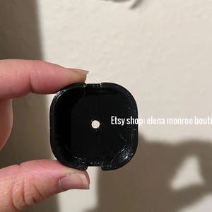 K&ouml;nnte beinhalten: Ein schwarzes, quadratisches Objekt mit einem kleinen Loch in der Mitte. Das Objekt hat abgerundete Ecken und scheint aus einem gl&auml;nzenden Material zu bestehen. Der Text auf dem Bild lautet "Etsy shop: elena monroe boutique".