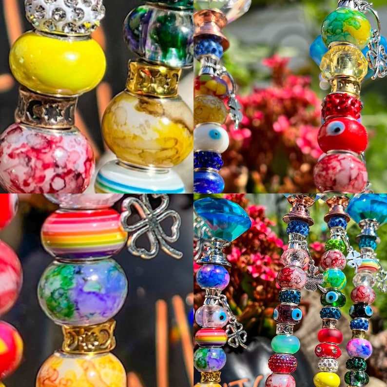 May include: A collection of colorful beaded keychains with charms, including a rainbow, shamrock, and evil eye. The keychains are made with glass beads, metal charms, and a variety of colors, including red, blue, green, yellow, and white.