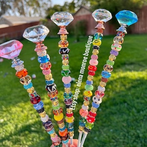 May include: Five colorful beaded keychains with crystal diamond charms. Each keychain features a different color scheme and assortment of beads, including clear, red, green, blue, yellow, and pink beads.