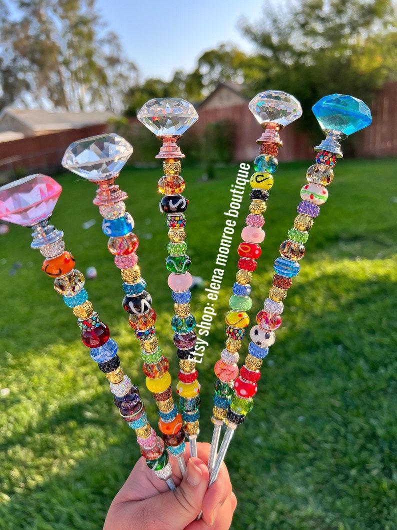 May include: Five colorful beaded keychains with crystal diamond charms. Each keychain features a different color scheme and assortment of beads, including clear, red, green, blue, yellow, and pink beads.