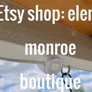 K&ouml;nnte beinhalten: Bild einer wei&szlig;en LED-Leuchte mit Metallring, montiert unter einem Holzbalken. Der Text "Etsy shop: elena monroe boutique" ist auf dem Bild &uuml;berlagert.