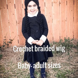 May include: A child wearing a black crochet wig with long braids, a black dress with white collar and cuffs, and black shoes. The text on the image reads "Crochet braided wig" and "Baby-adult sizes."
