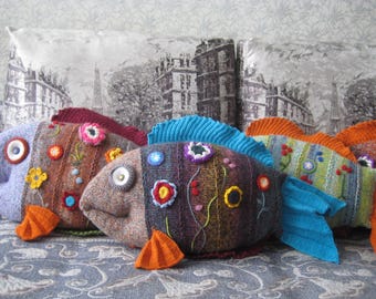 Dekoratives Kissen ist ein gestrickter Spielzeugfisch, eine lustige Dekoration und ein tolles handgemachtes Geschenk.