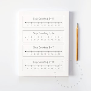 May include: A white notepad with black text showing skip counting by 5, 6, 7, and 8. A yellow pencil rests on the right side. The notepad is on a white surface.