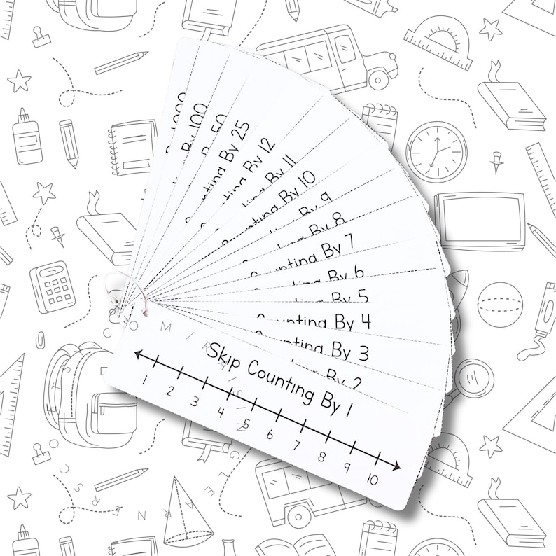 May include: A set of white flashcards fanned out, featuring text for skip counting. The cards are labeled with numbers and phrases like "Counting By 1" and "Counting By 25." The background is a white surface with school-themed line drawings.