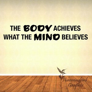 May include: A motivational quote on a beige wall reads "The body achieves what the mind believes." A hummingbird graphic is at the bottom of the image with the text "Hummingbird Graphix".