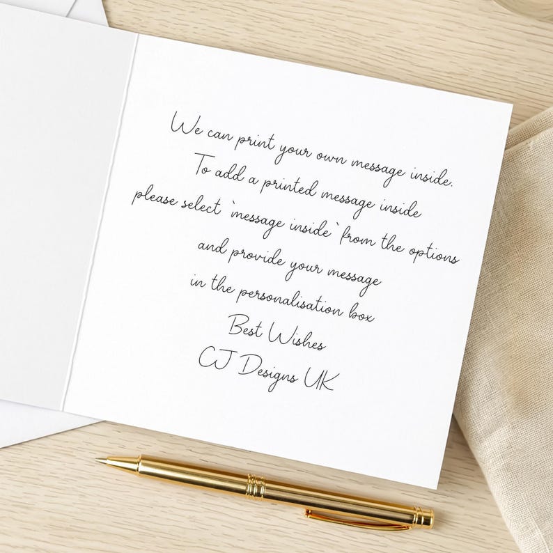 a handwritten note on a white card with a gold pen, placed on a wooden surface.