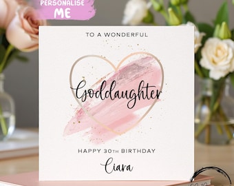 Peut inclure: Carte d'anniversaire personnalisée pour une filleule. La carte présente le texte "To a Wonderful Goddaughter" et "Happy 30th Birthday Ciara". Le design comprend un contour de cœur doré avec un coup de pinceau rose.