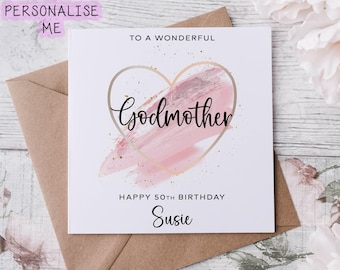 Peut inclure: Carte de vœux blanche avec un cœur rose et des détails dorés. Le texte dit : « À une merveilleuse marraine, joyeux 50e anniversaire Susie ». La carte est sur une enveloppe marron.