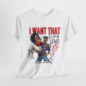 Puede incluir: Camiseta blanca con un estampado gráfico de una pareja, una mujer con cabello rojo y un hombre con una camisa azul, con el texto "I WANT THAT kind of LOVE" y "DeWayne and Whitley" debajo del gráfico.