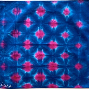 May include: A blue and pink tie-dye fabric with a repeating starburst pattern.