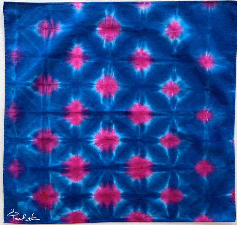 May include: A blue and pink tie-dye fabric with a repeating starburst pattern.