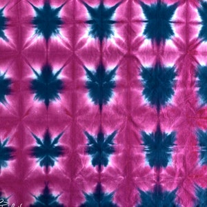 May include: A pink and blue tie-dye fabric with a repeating starburst pattern.