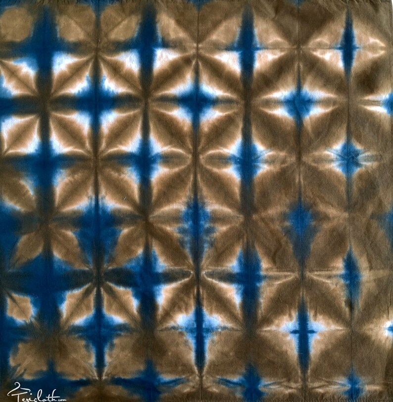 May include: A brown and blue tie-dye fabric with a geometric pattern. The fabric has a repeating pattern of stars and squares.
