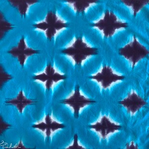 May include: A blue and purple tie-dye fabric with a repeating diamond pattern.