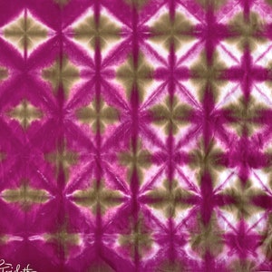 May include: A close-up of a pink and brown tie-dye fabric with a geometric pattern. The fabric has a soft, crinkled texture.