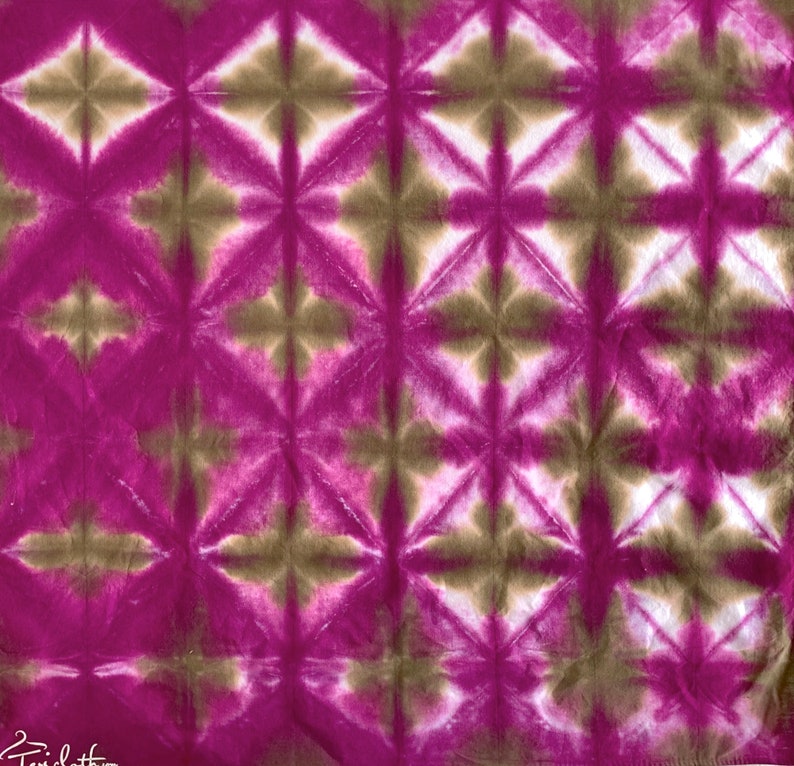 May include: A close-up of a pink and brown tie-dye fabric with a geometric pattern. The fabric has a soft, crinkled texture.