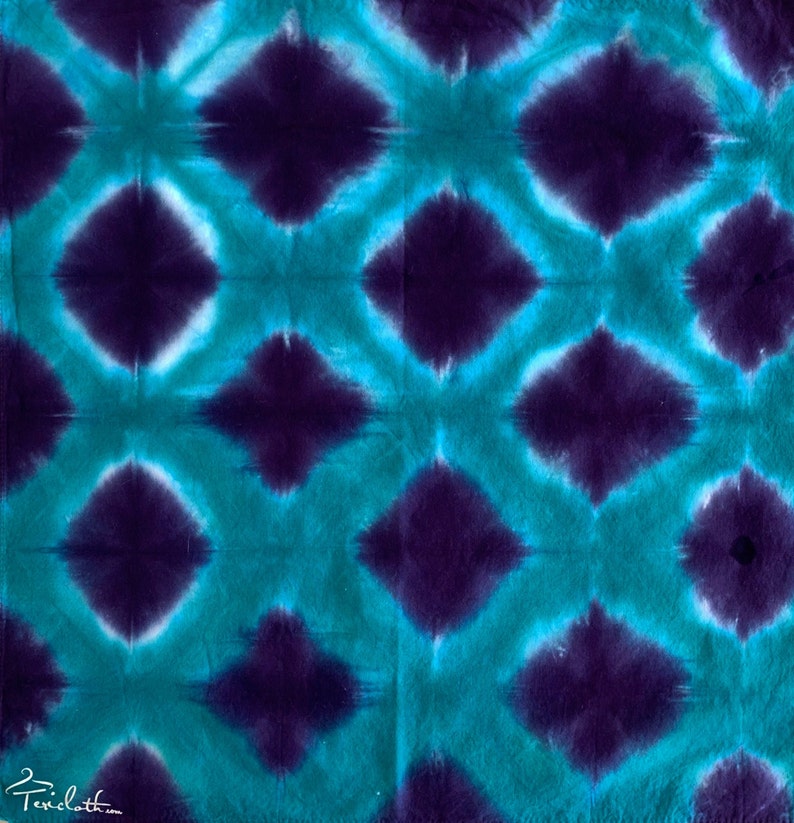 May include: A tie-dye fabric with a repeating pattern of teal and purple diamond shapes.