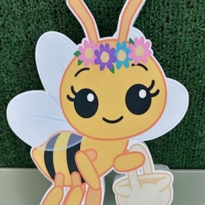 May include: A cartoon bee with a yellow body, black and yellow stripes, and white wings. The bee wears a flower crown and carries a small basket. The letter "F" is in the bottom right corner.