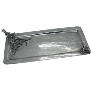 May include: A rectangular silver-toned metal tray with a hammered texture. One corner features a decorative cast metal bird perched among flowers and leaves, while the opposite corner displays a smaller matching floral accent piece.