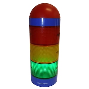 May include: A cylindrical signal light with a red dome top, a blue band, and three stacked translucent sections in red, yellow, and green with a textured grid pattern. The base is blue and features the white text KADAMS printed on the front.