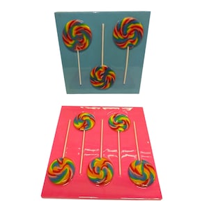 May include: Two sets of rainbow swirl lollipops on sticks. One set is on a light blue background, the other on a pink background. Each lollipop has a spiral design with red, yellow, green, and blue colors. The lollipops are arranged in rows.