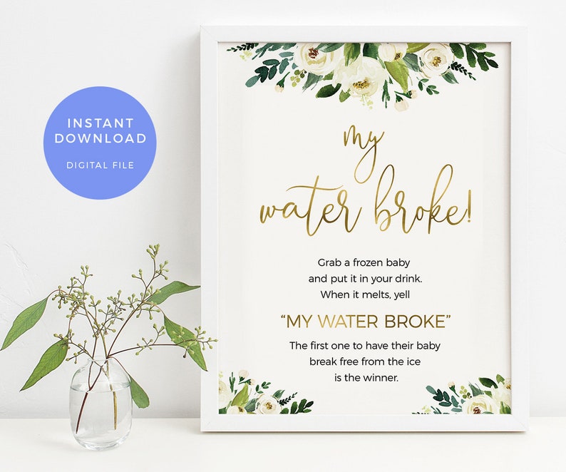 May include: White printable sign with gold text that says "my water broke!" and instructions for a baby shower game. The sign is decorated with white flowers and green leaves.