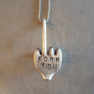 Puede incluir: Un collar de plata con un colgante en forma de tenedor que dice "FORK YOU".